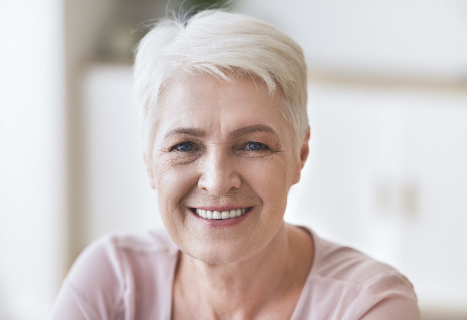 Portrait of senior business woman smiling at camera, home interior